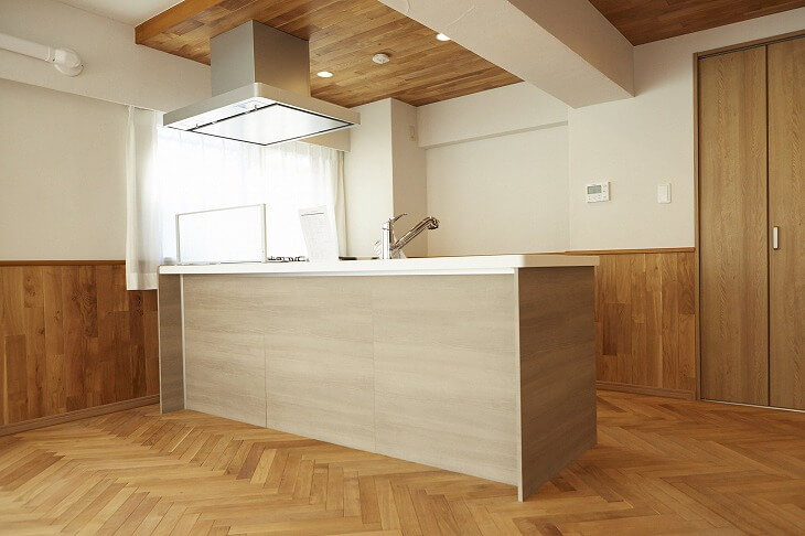 LDKのキッチン部分のみ無垢材天井にした例。圧迫感が軽減される